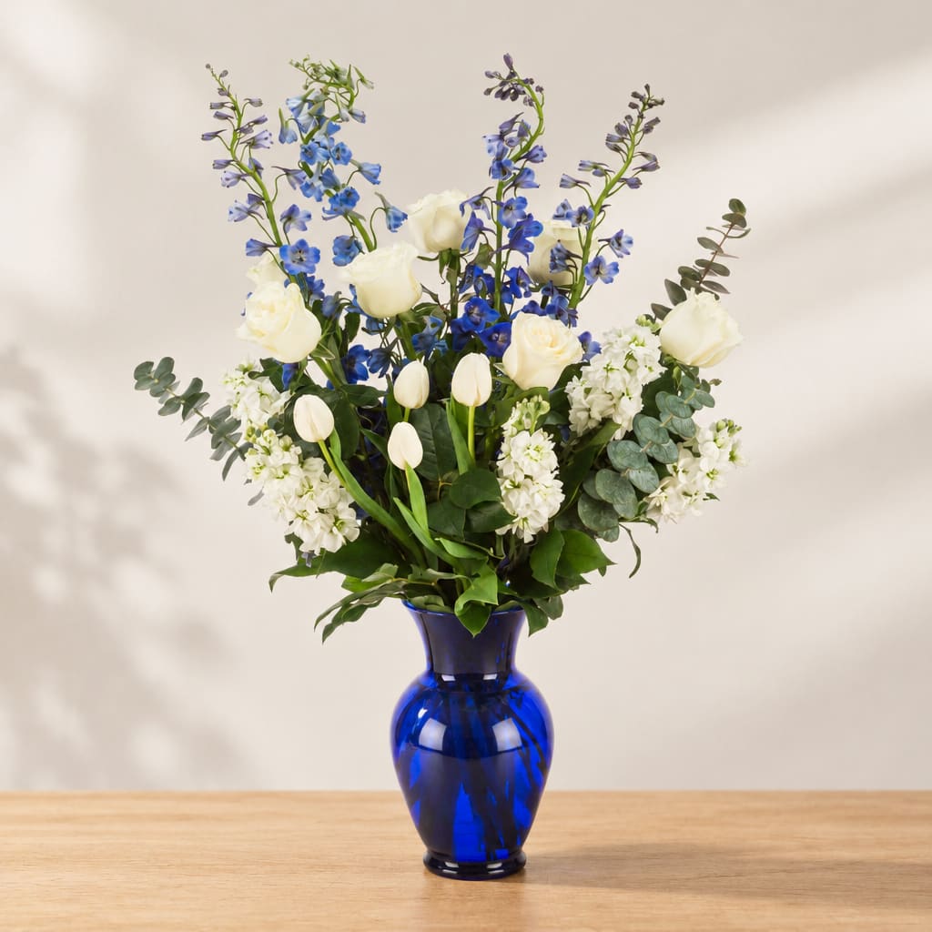 Blue and white floral arrangement in a cobalt glass vase