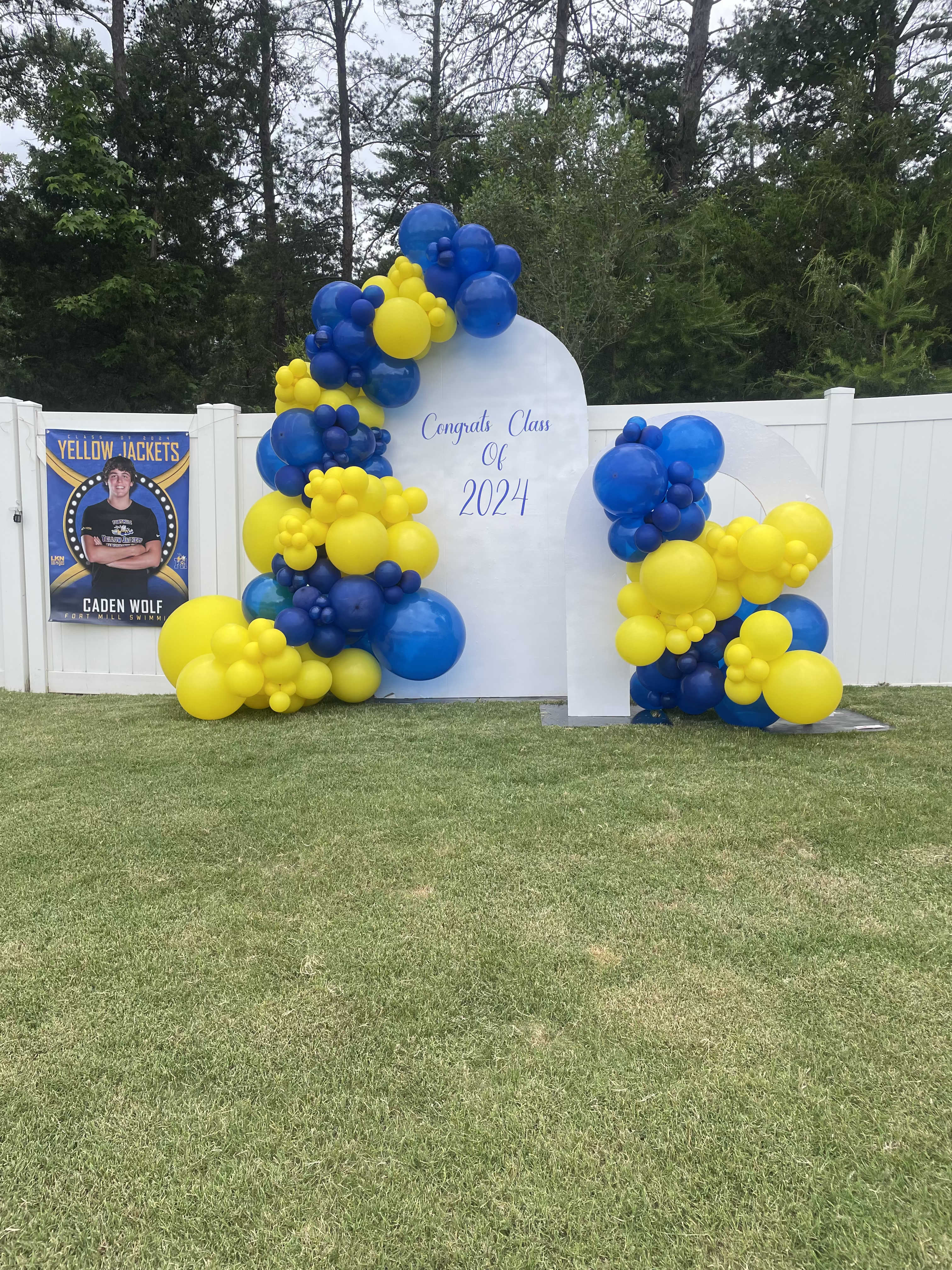 Blue and yellow balloon display around a graduation sign