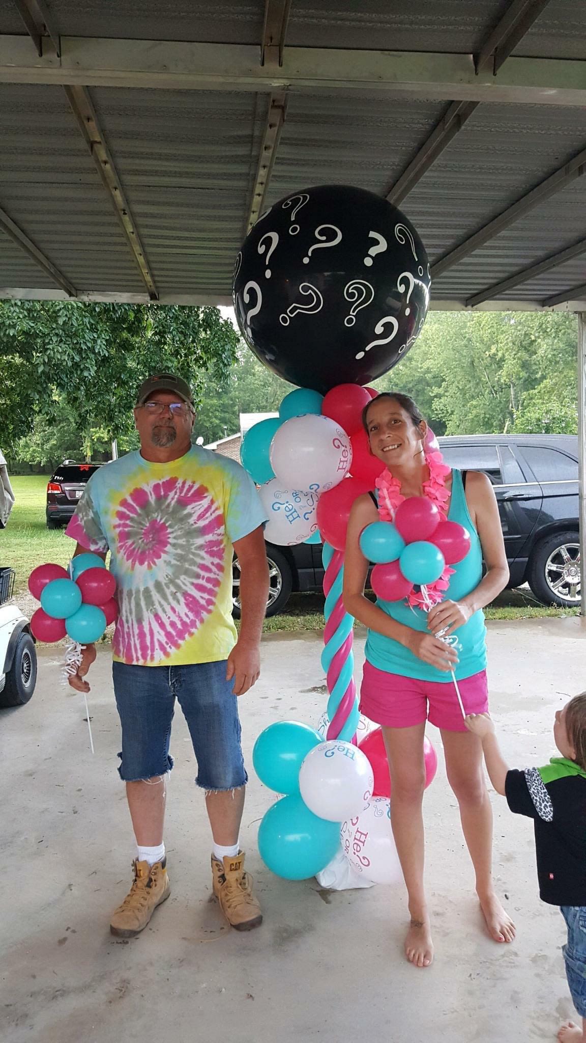 People holding colorful balloons under a covered patio