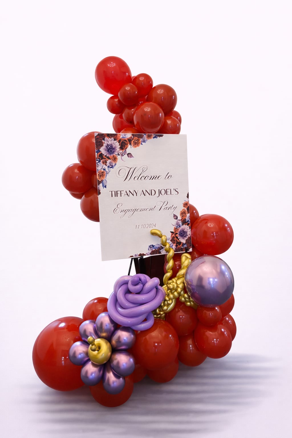 Red and purple balloon display with an engagement party sign