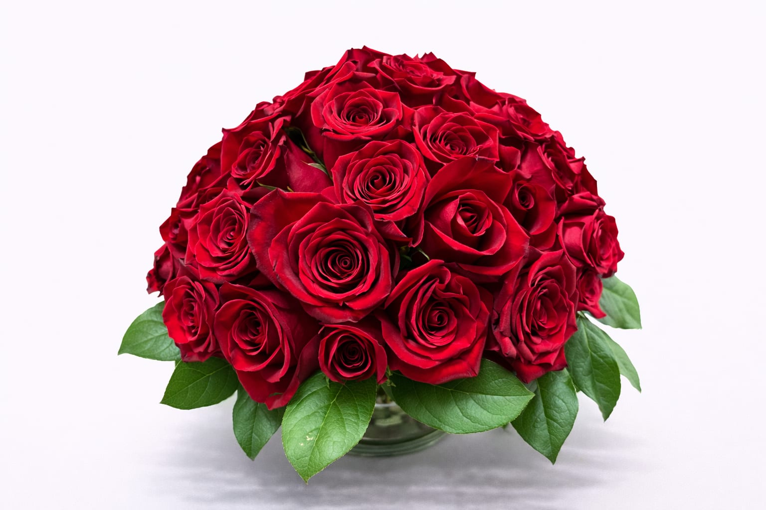 Round bouquet of red roses in a glass vase