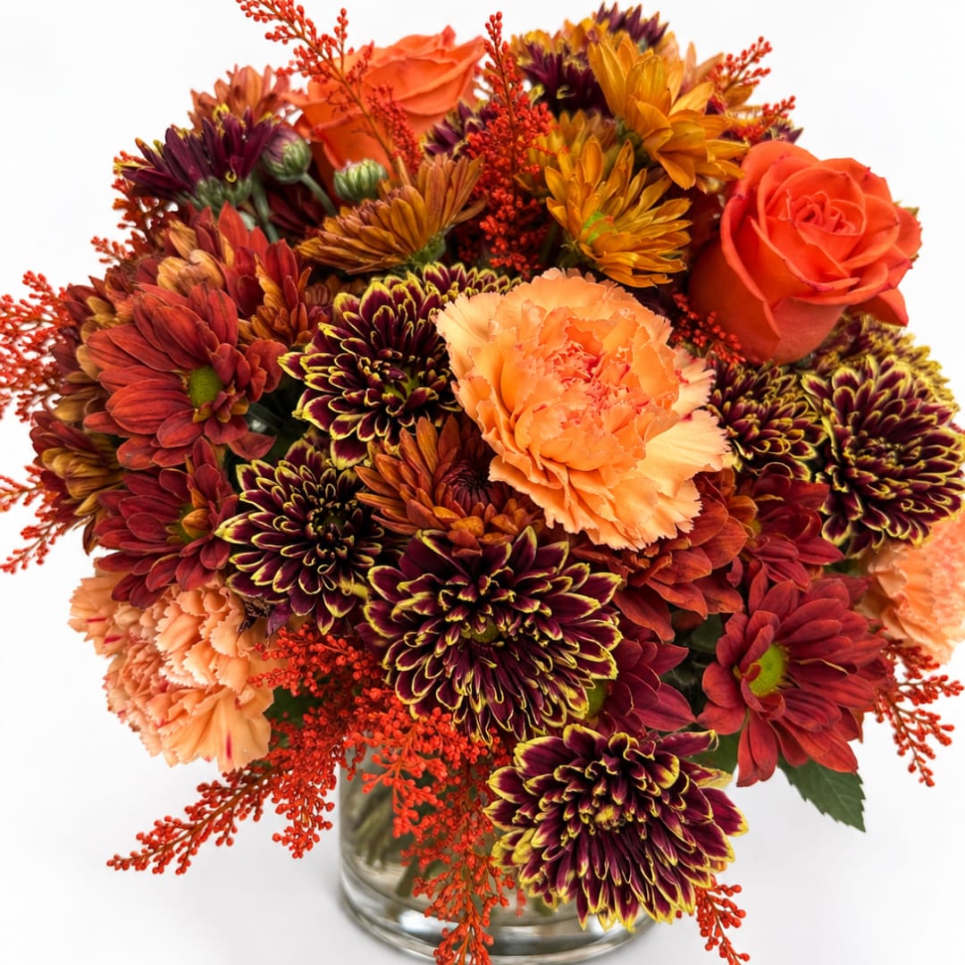 Orange roses and burgundy chrysanthemums in a glass vase