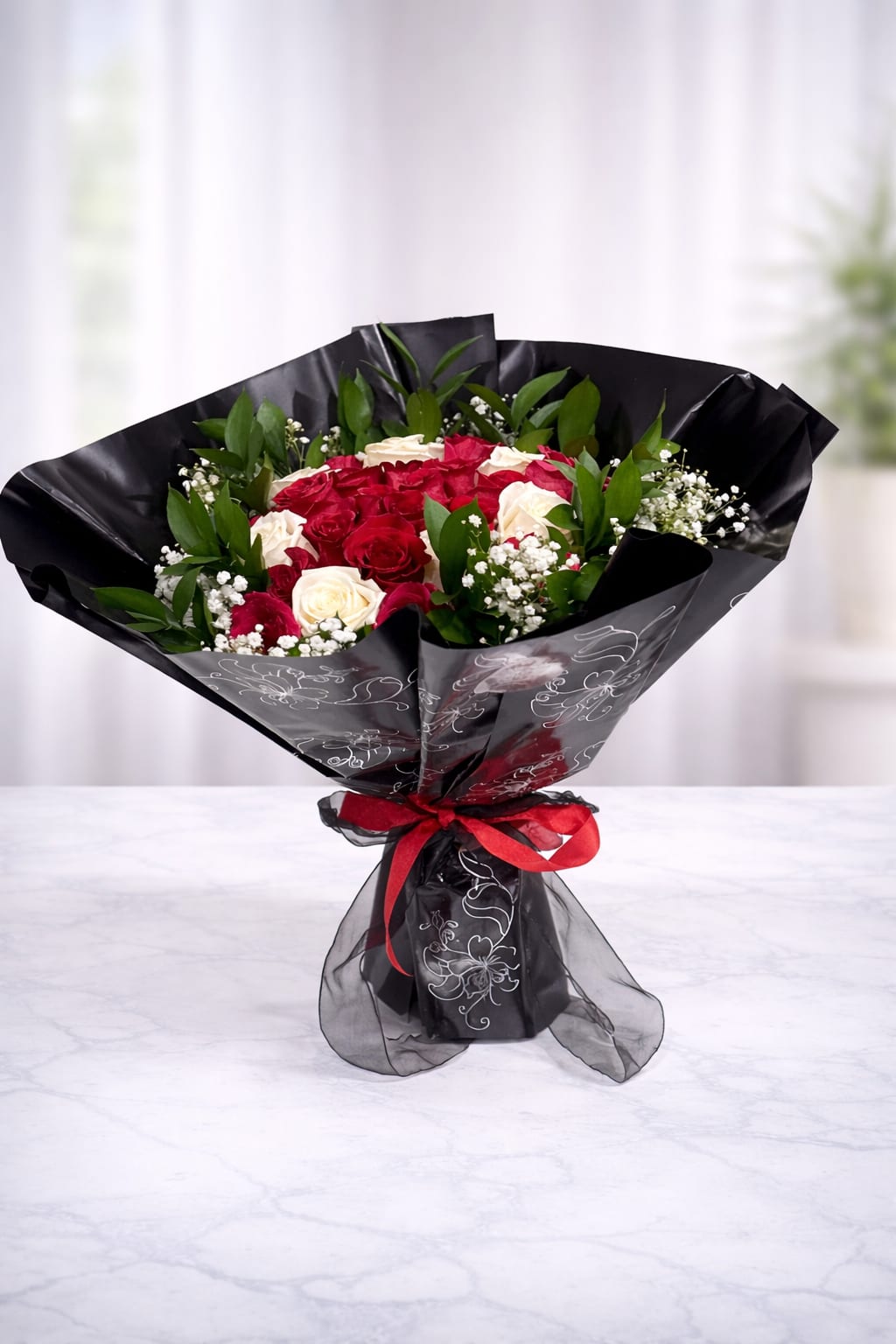 Bouquet of red and white roses wrapped in black paper with a red ribbon