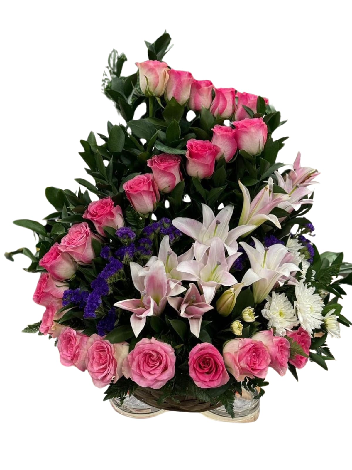 Pink roses and white lilies arranged in a basket with purple accents