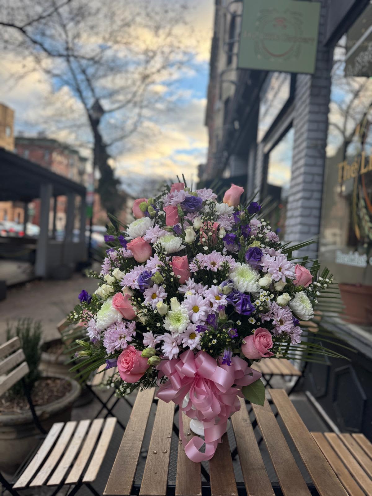 Large bouquet of pink and purple flowers tied with a pink ribbon