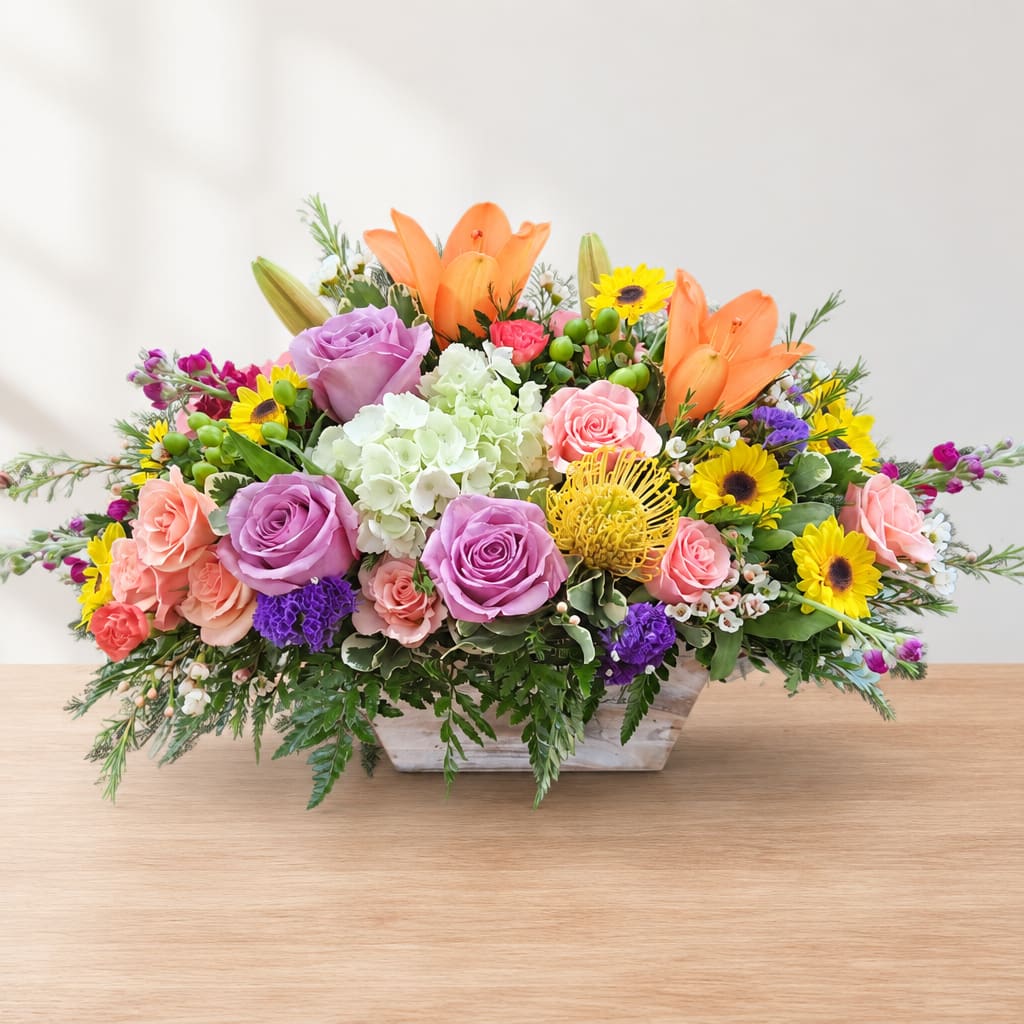 Colorful mixed flower arrangement in a low rectangular container