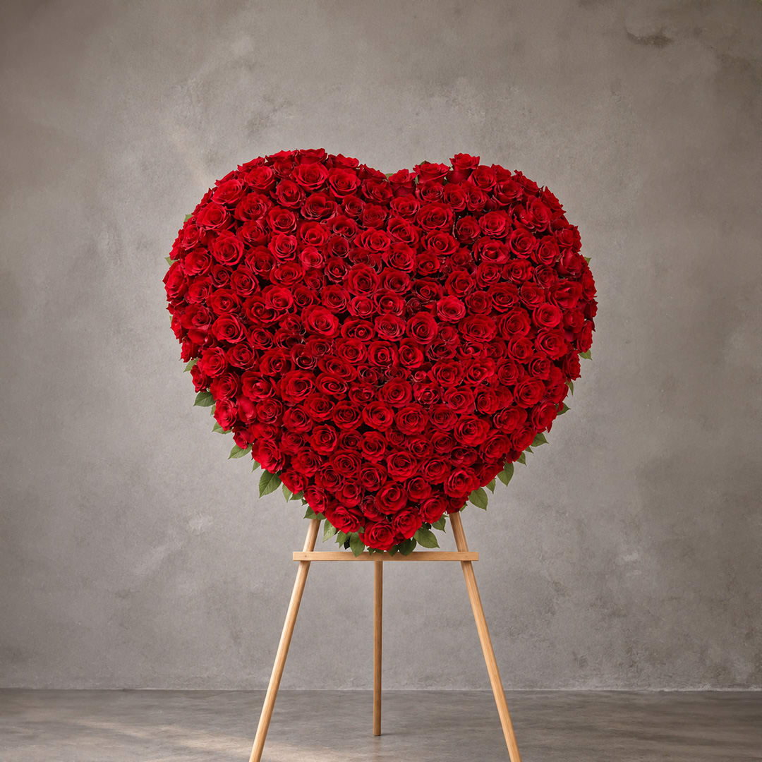 Heart-shaped arrangement of red roses on a wooden easel