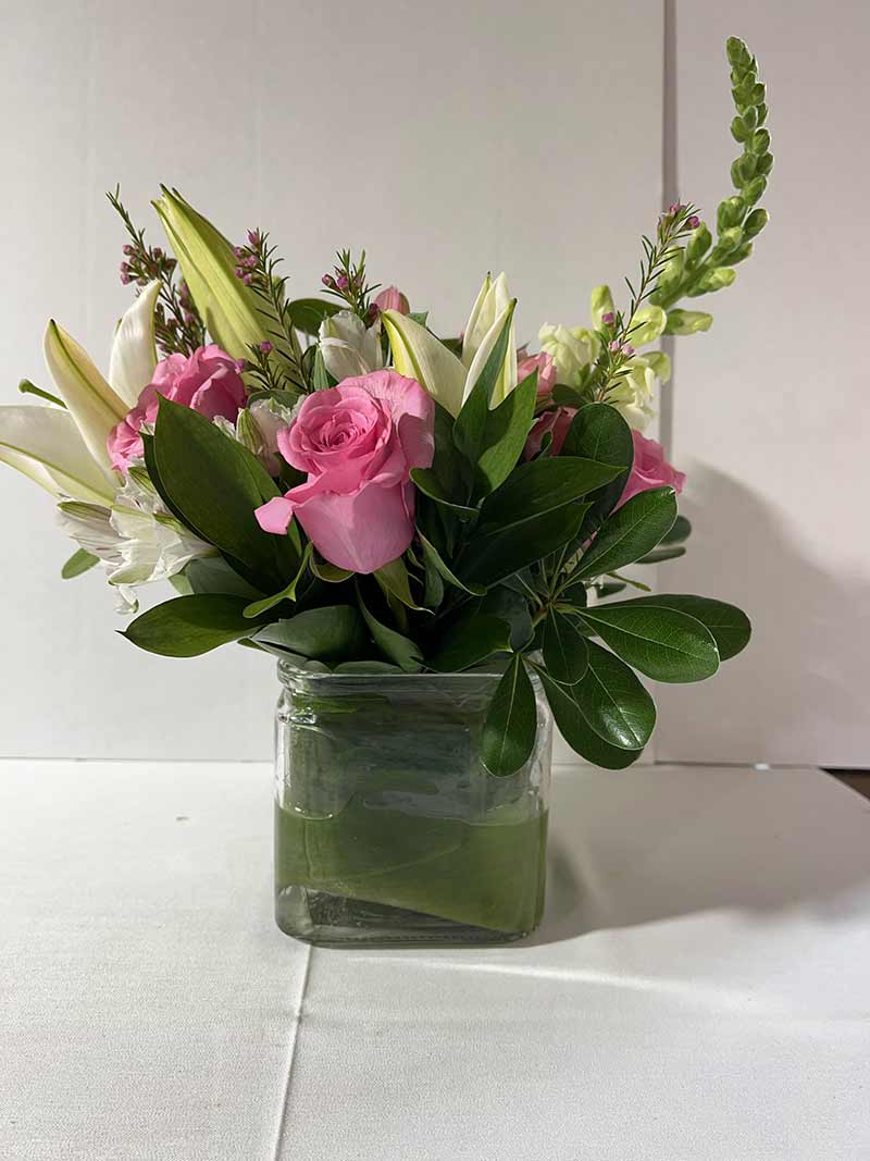 Pink roses and white lilies in a clear glass vase