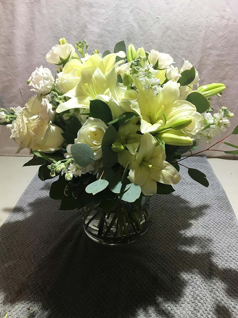 White lily and rose bouquet in a clear glass vase