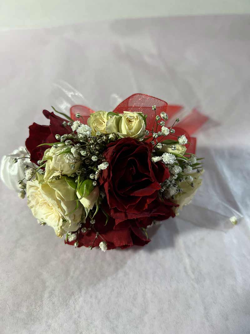 Bouquet of red and cream roses wrapped in clear plastic