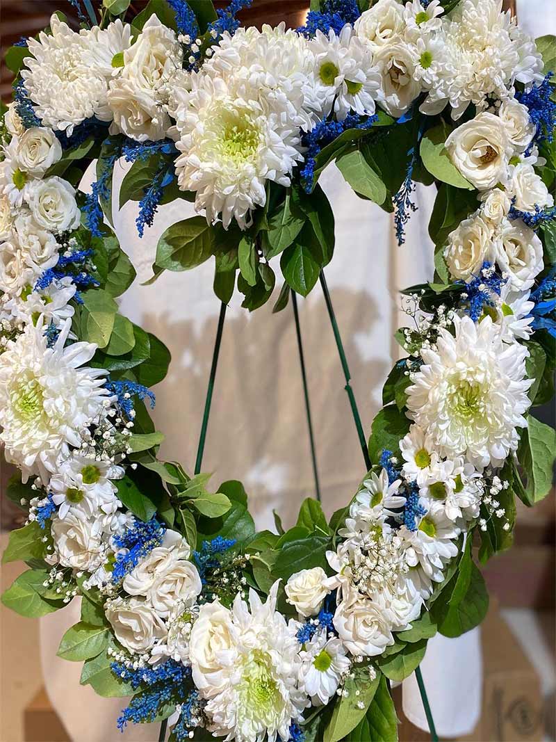 Heart-shaped floral wreath with white blooms and blue accents