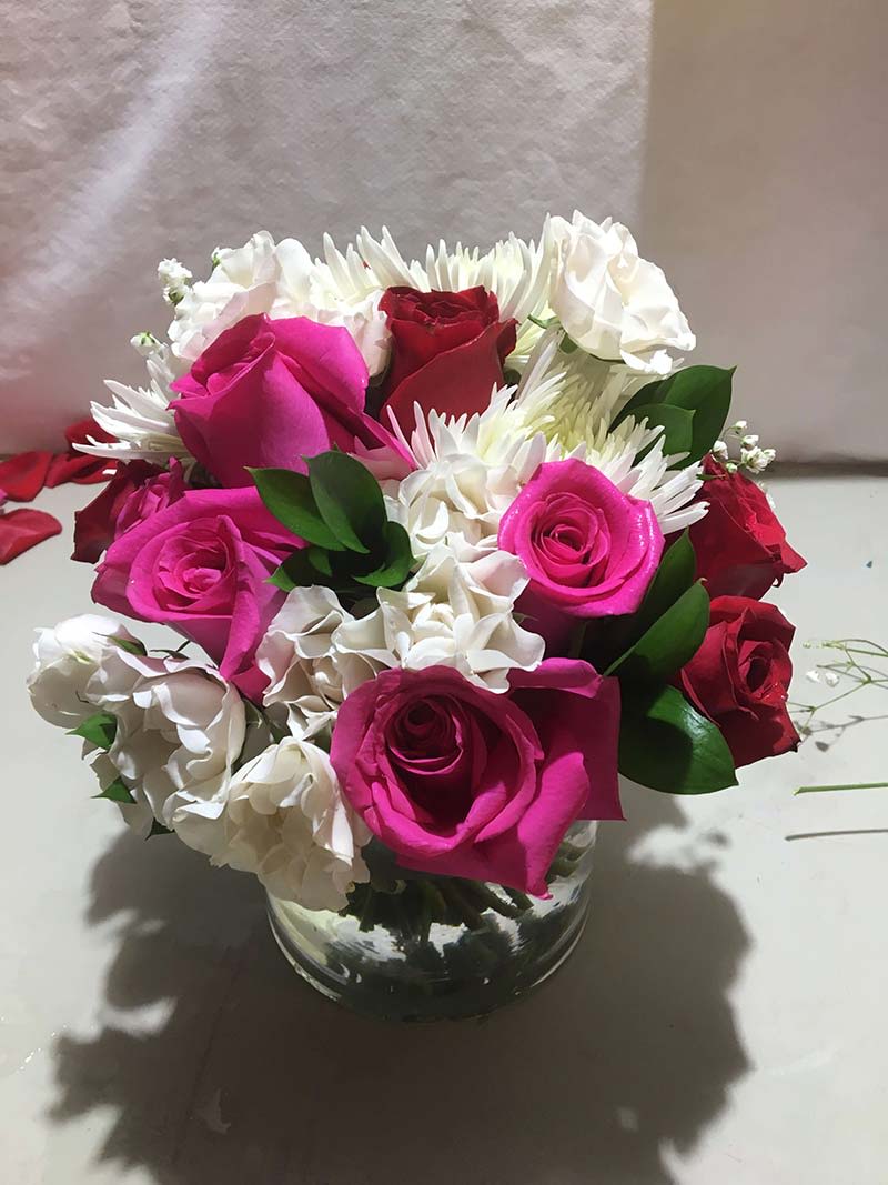 Pink and white roses with white daisies in a glass vase