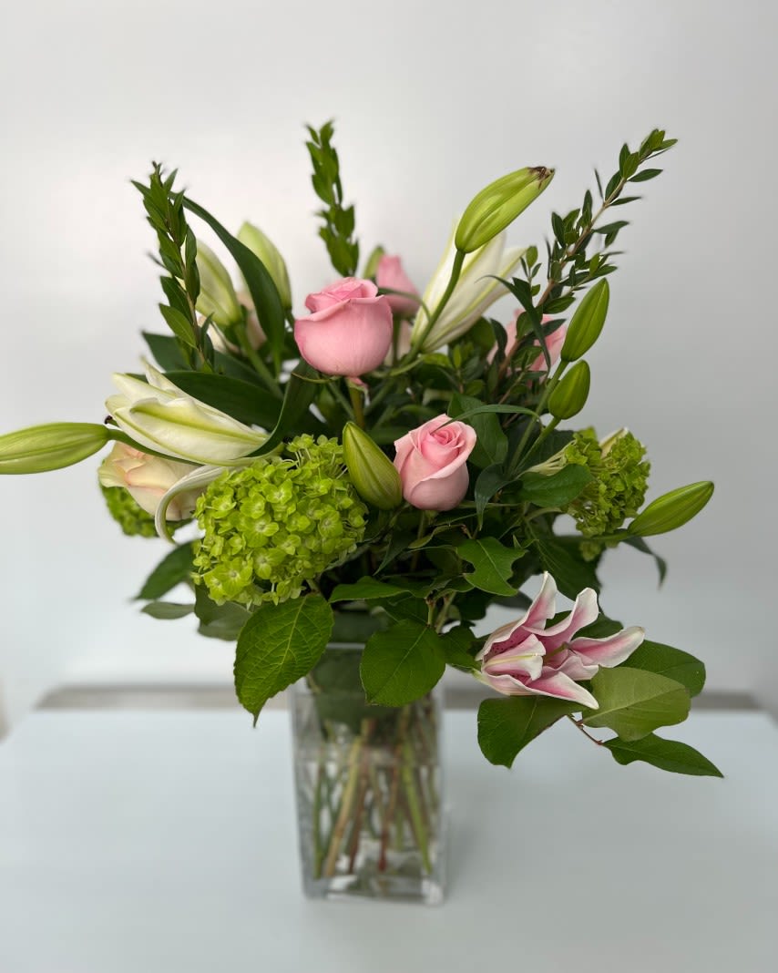 Pink roses and lilies in a clear glass vase