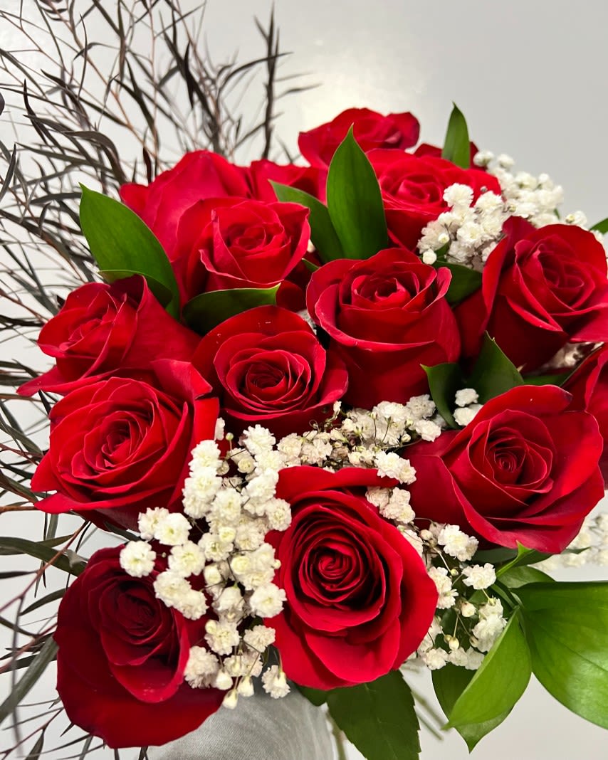 Bouquet of red roses with white baby's breath and green leaves