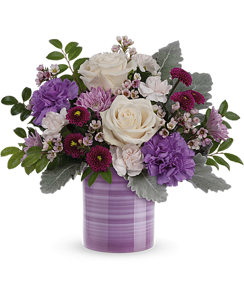Purple and white floral arrangement in a lavender vase