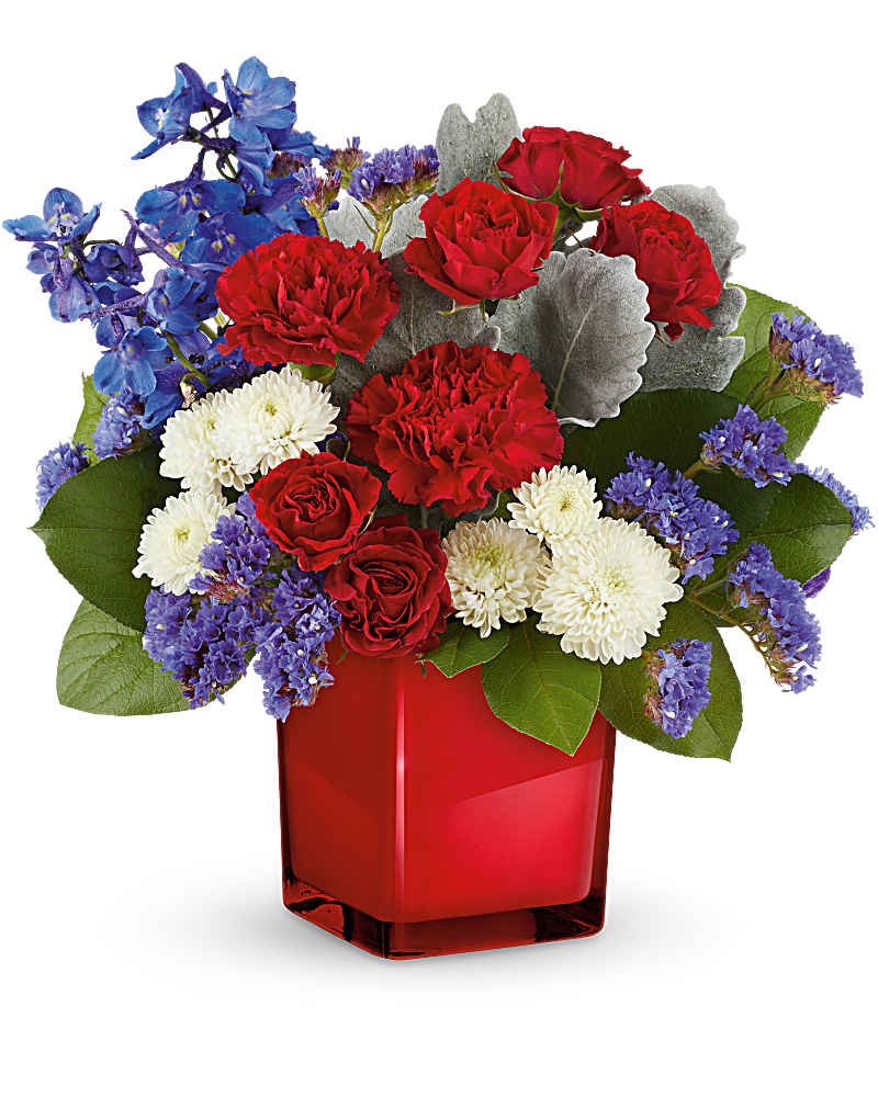 Red roses, white mums, and blue flowers in a red vase