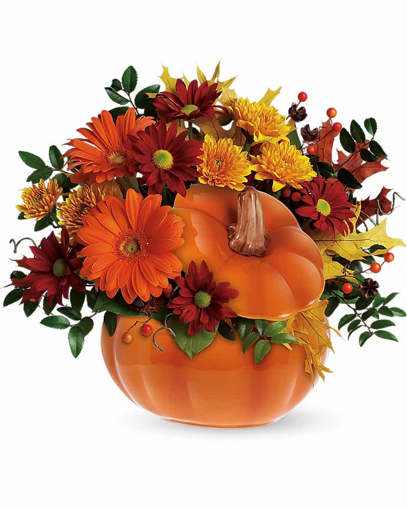 Autumn flower arrangement in a pumpkin-shaped vase with orange and red blooms