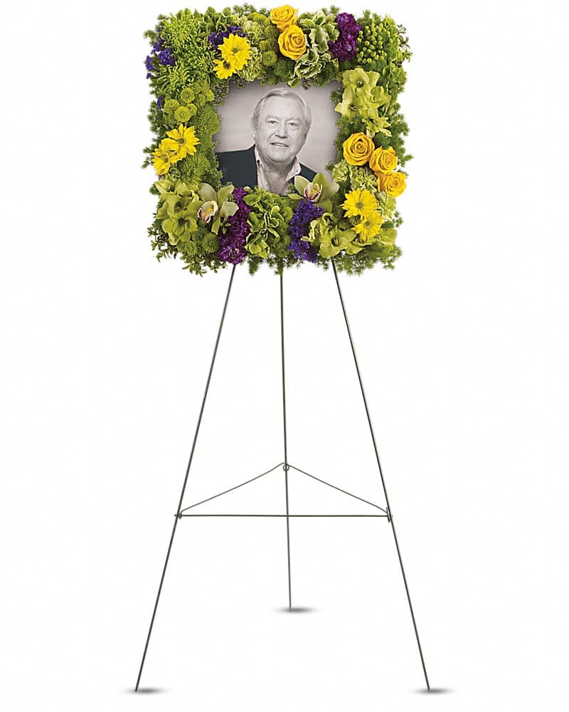 Standing floral tribute frame with a portrait photo in the center