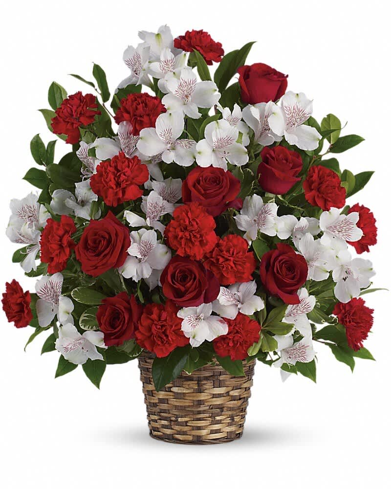 Red roses and carnations with white alstroemeria in a woven basket
