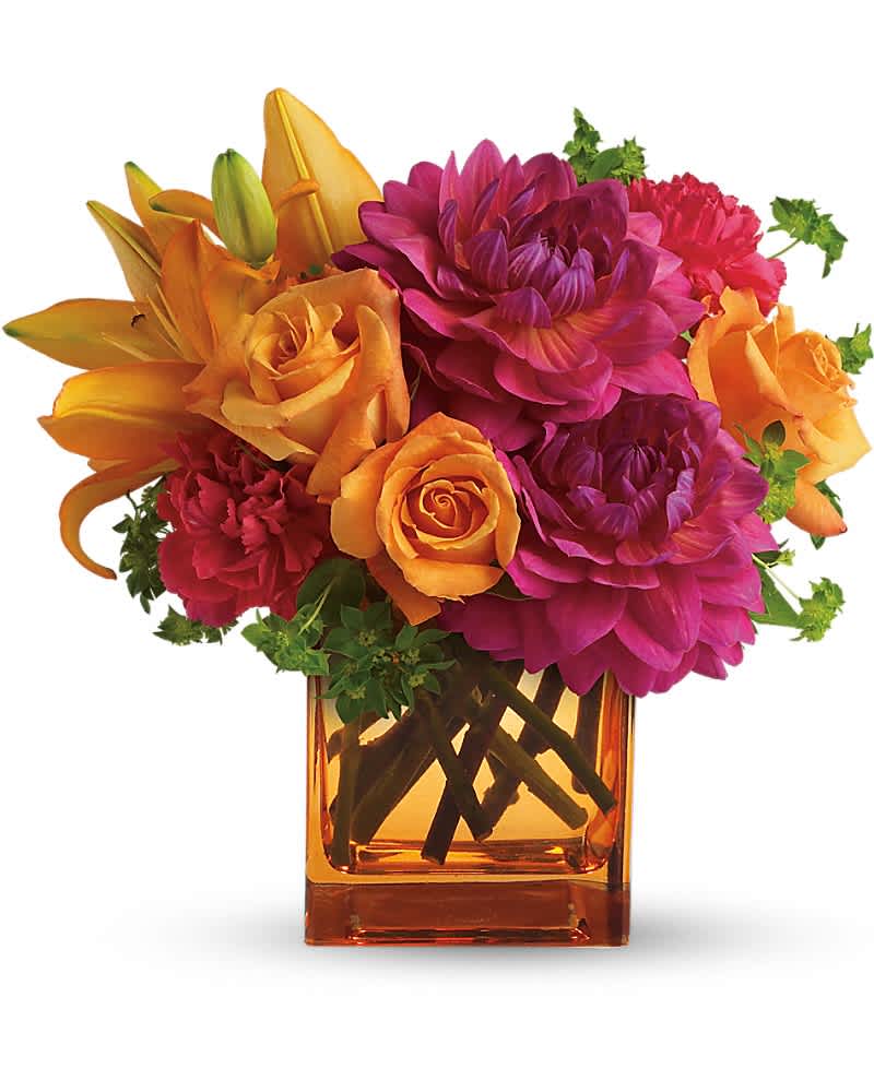 Orange and magenta flowers arranged in an amber glass vase