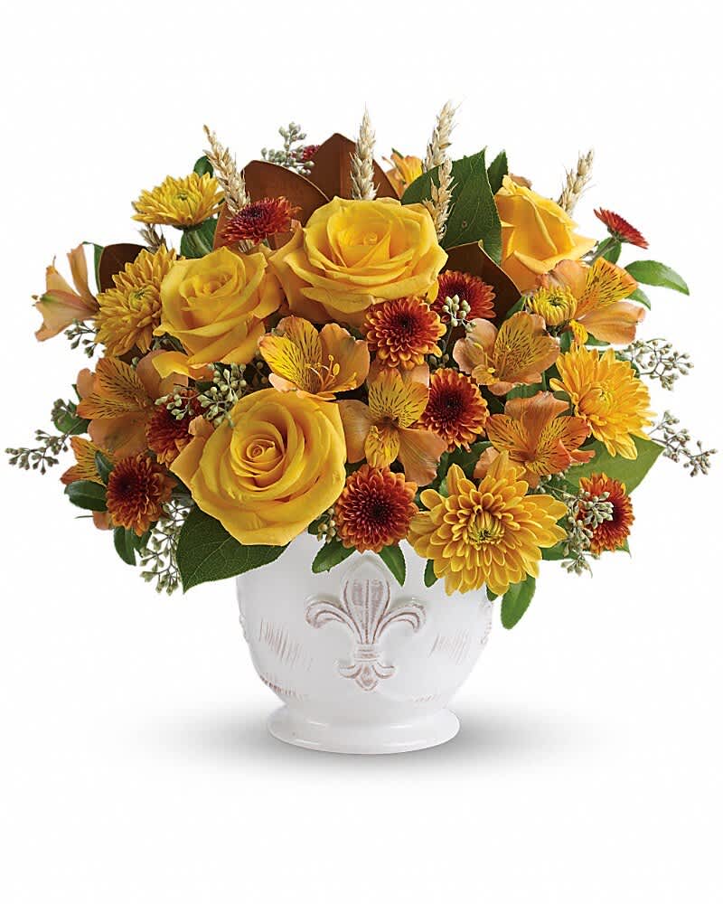 Yellow roses and autumn flowers arranged in a white vase