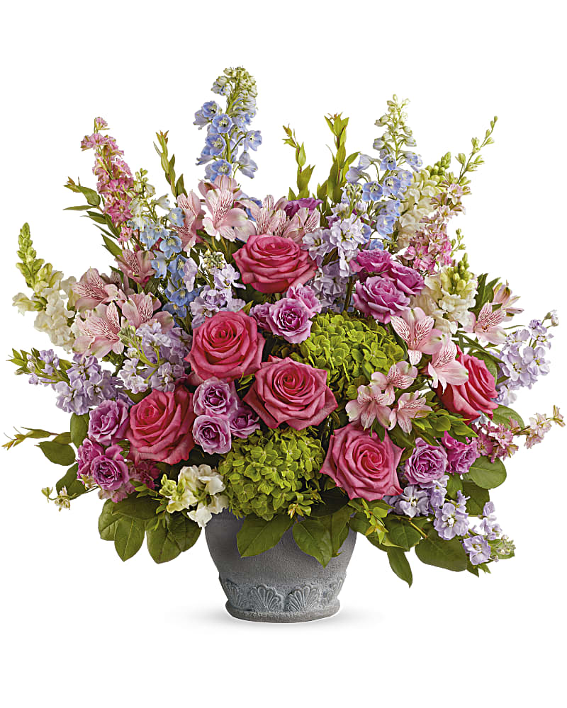 Pink roses and lavender flowers arranged in a gray vase