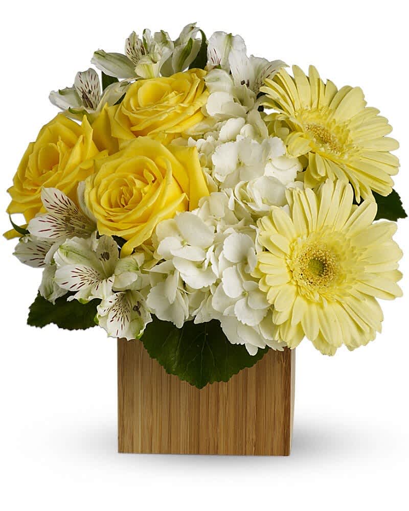Yellow roses and gerbera daisies in a wooden cube vase