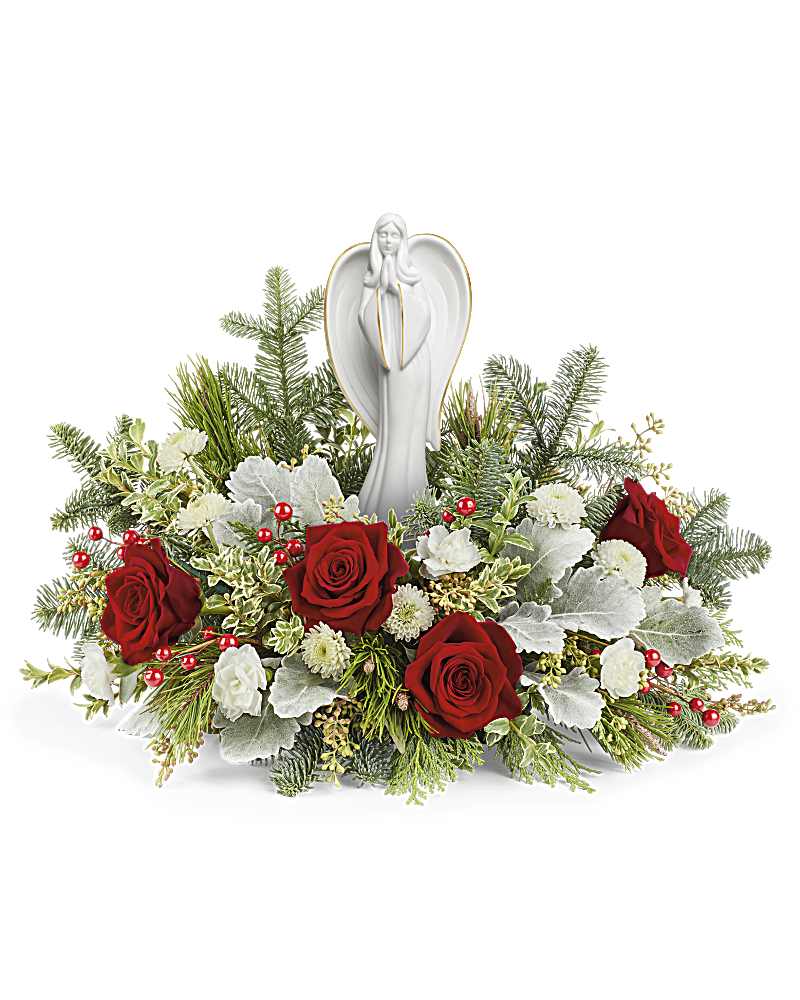 Red roses and white flowers arranged around a white angel figurine