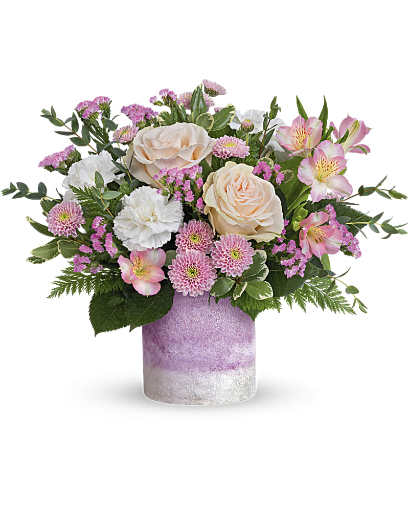 Pink and white mixed flower arrangement in a lavender vase