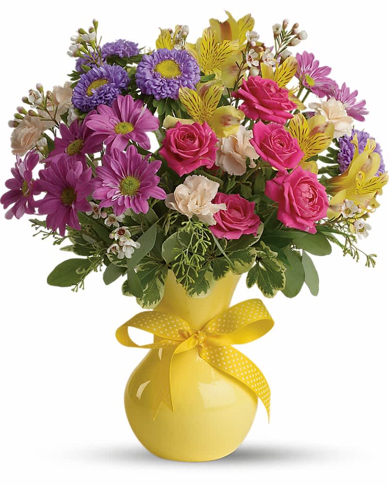 Bouquet of pink, purple, and yellow flowers in a yellow vase with a ribbon