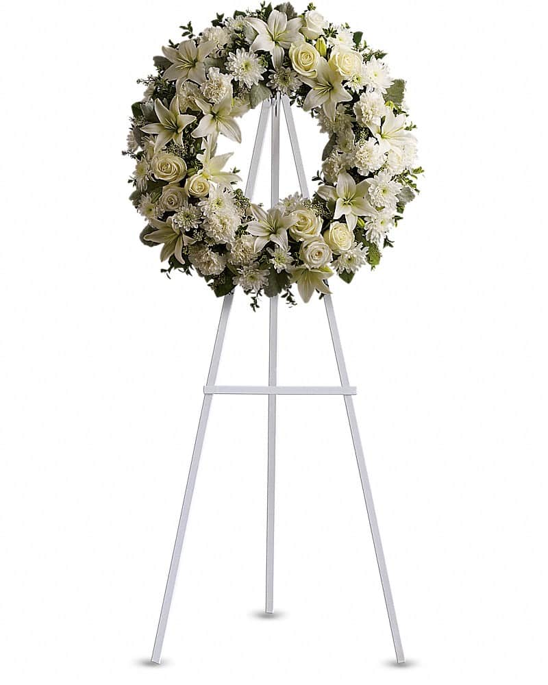 White floral wreath on a metal easel stand
