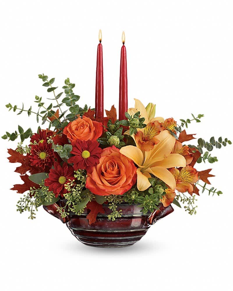 Autumn floral centerpiece with two red candles in a dark glass bowl