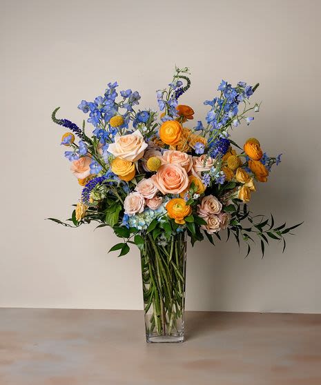 Twilight Sands Arrangement - A vibrant tribute to coastal summer warmth, this arrangement features a rich blend of soft peach contrasted against cool blues.
