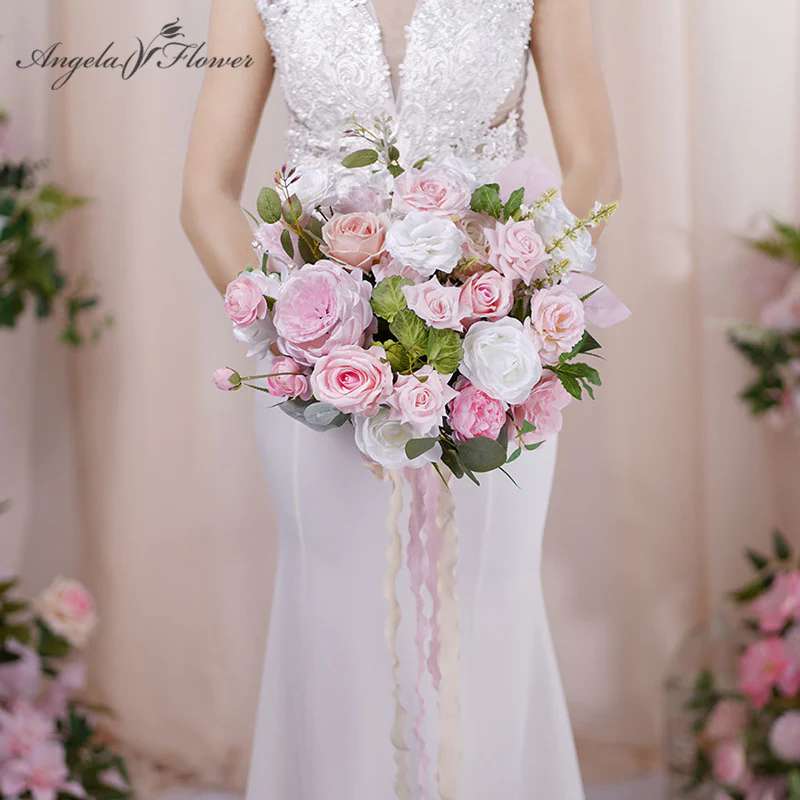 Bride holding a pink and white rose bouquet with trailing ribbons