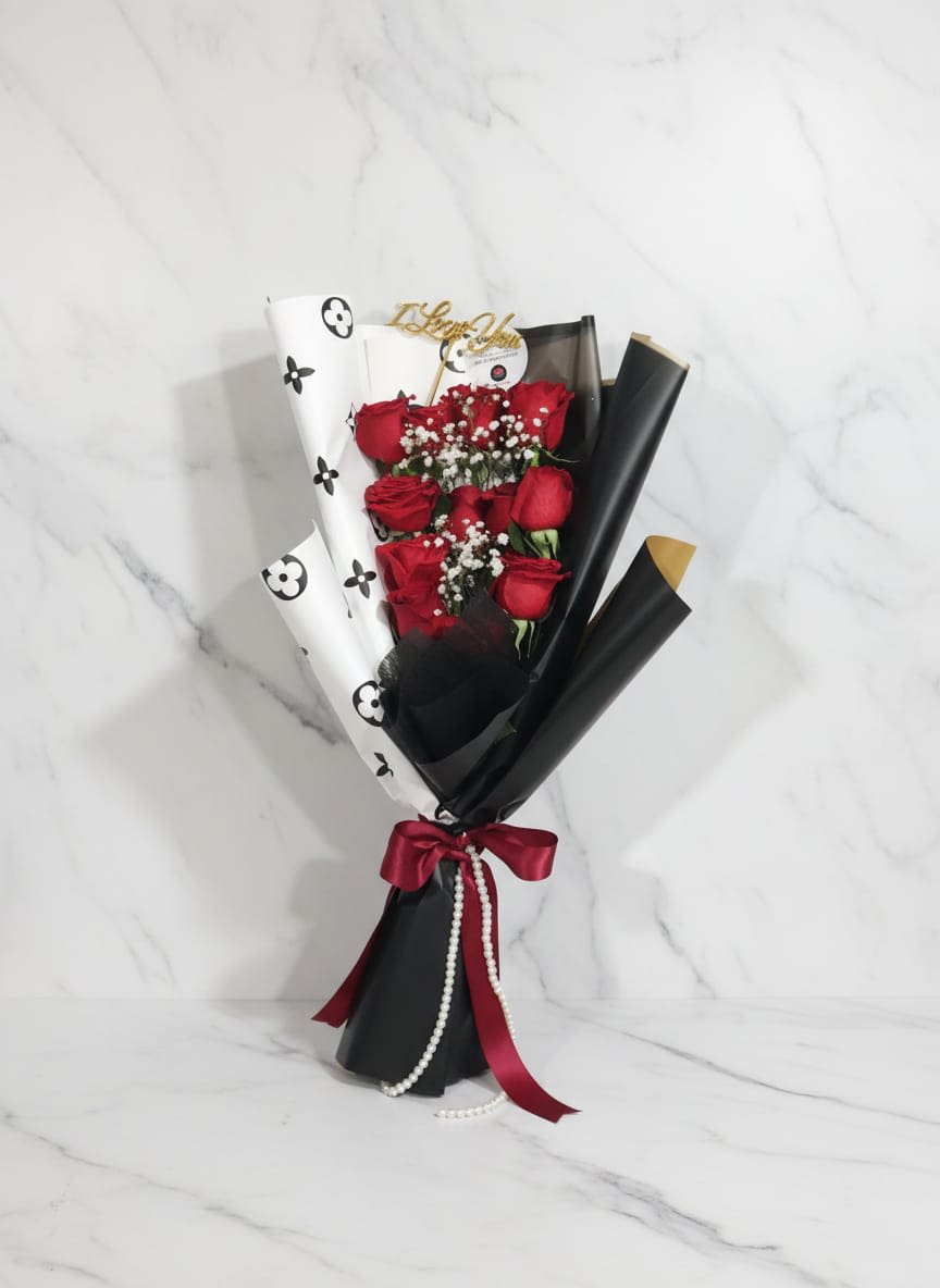 Midnight Romance - Bold, elegant, and irresistibly romantic, this stunning hand tied bouquet of red beautifull roses warpped in sleek black and white paper, finished with a deep red ribbon. The design can change according to the client and the disponibility of materials.  Coqueto, elegante e irresistiblemente romantico, esta preciosura de ramos de rosas rojas, enrolladas con papel negro y blanco, y como toque final atadas con liston rojo. El ramo puede cambiar de acuerdo a los gustos del cliente y los materiales disponibles
