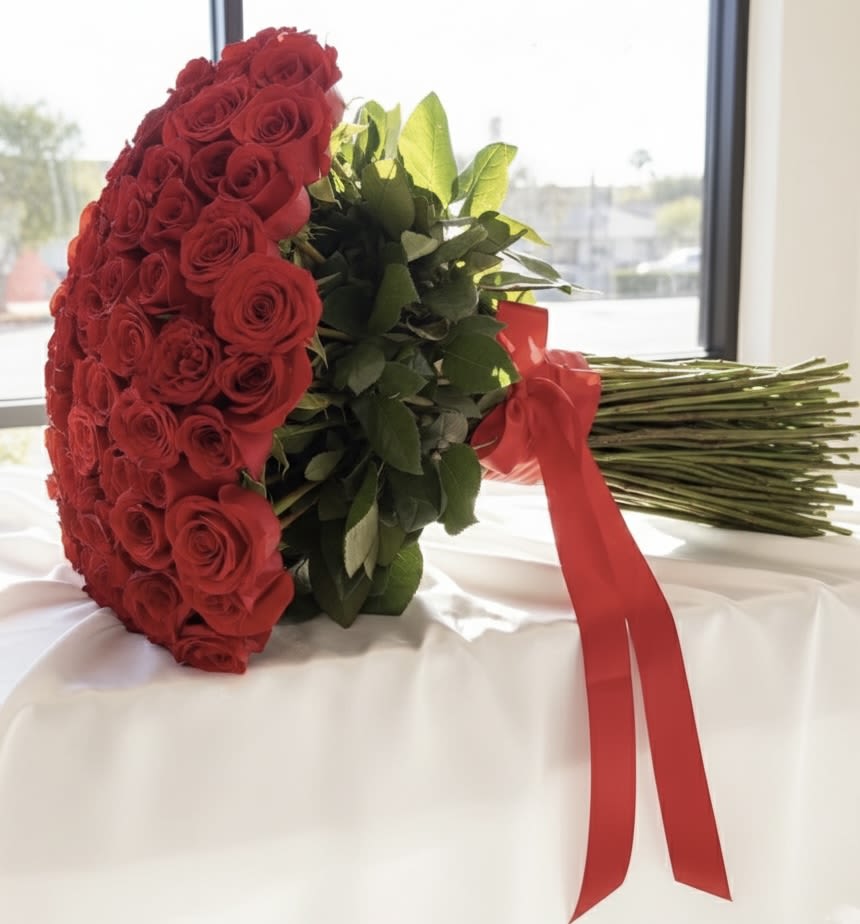 Large bouquet of red roses wrapped with a red ribbon