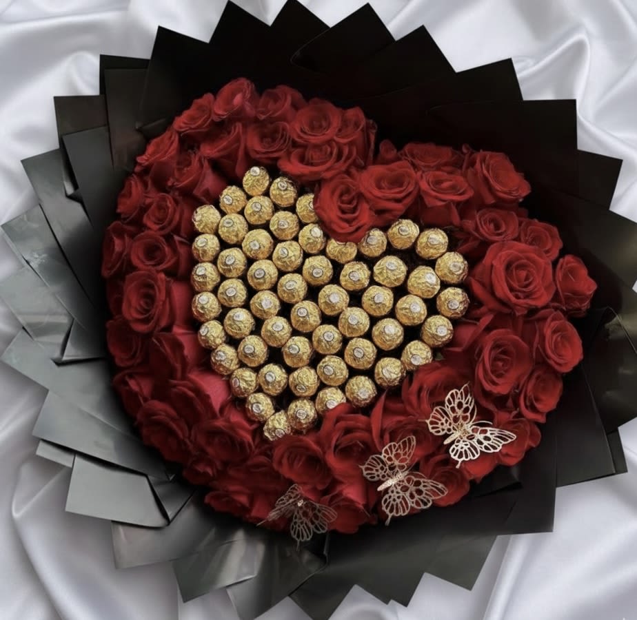 Heart-shaped bouquet of red roses with gold-wrapped chocolates and butterfly accents