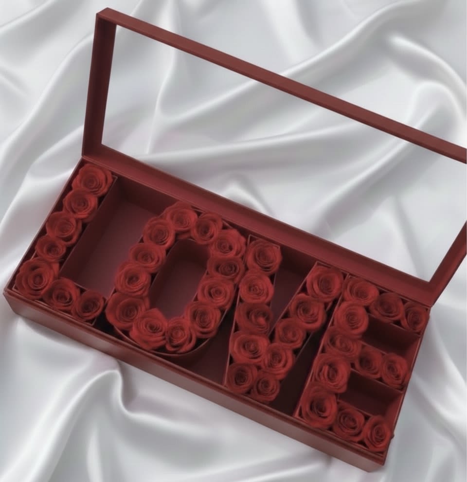 Red roses arranged in a gift box spelling "LOVE"
