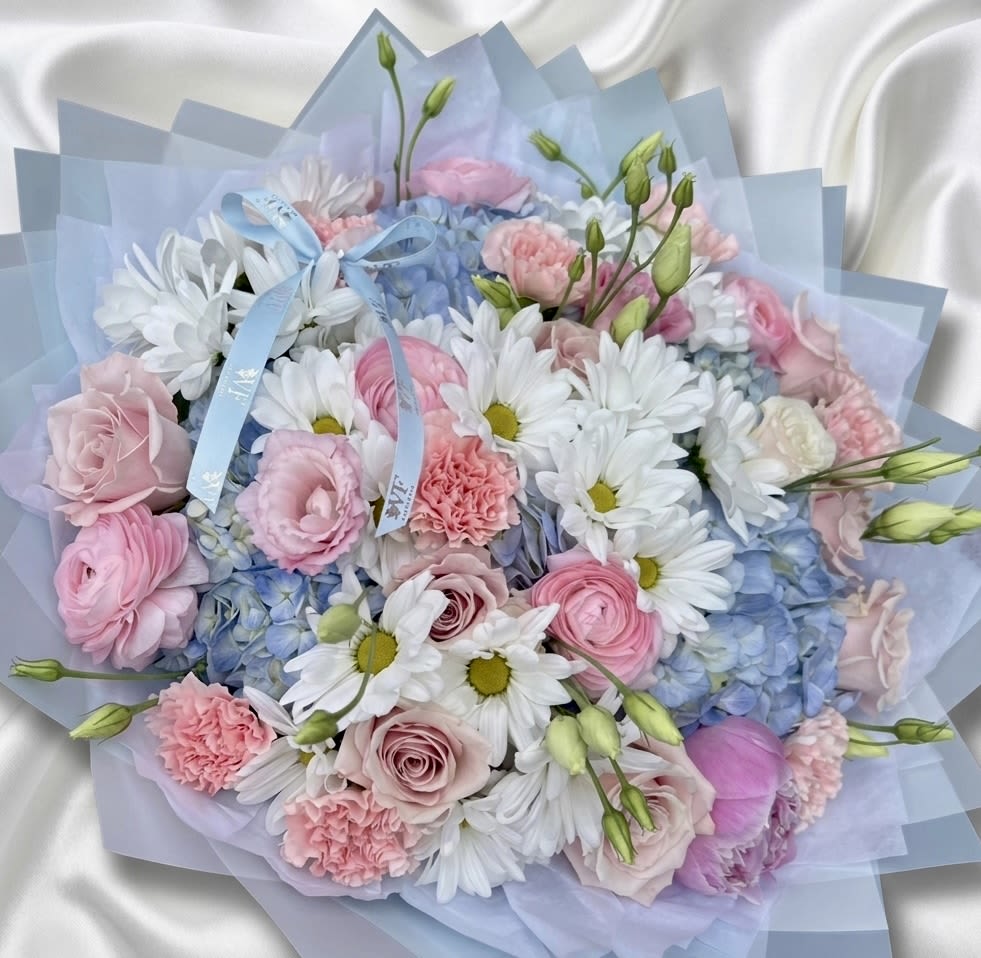 Pastel bouquet of pink and white flowers with blue wrapping