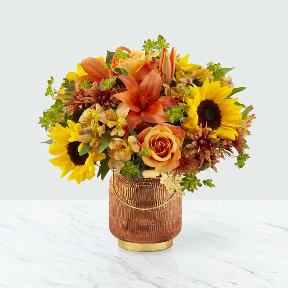 Orange and yellow mixed bouquet in a textured amber vase