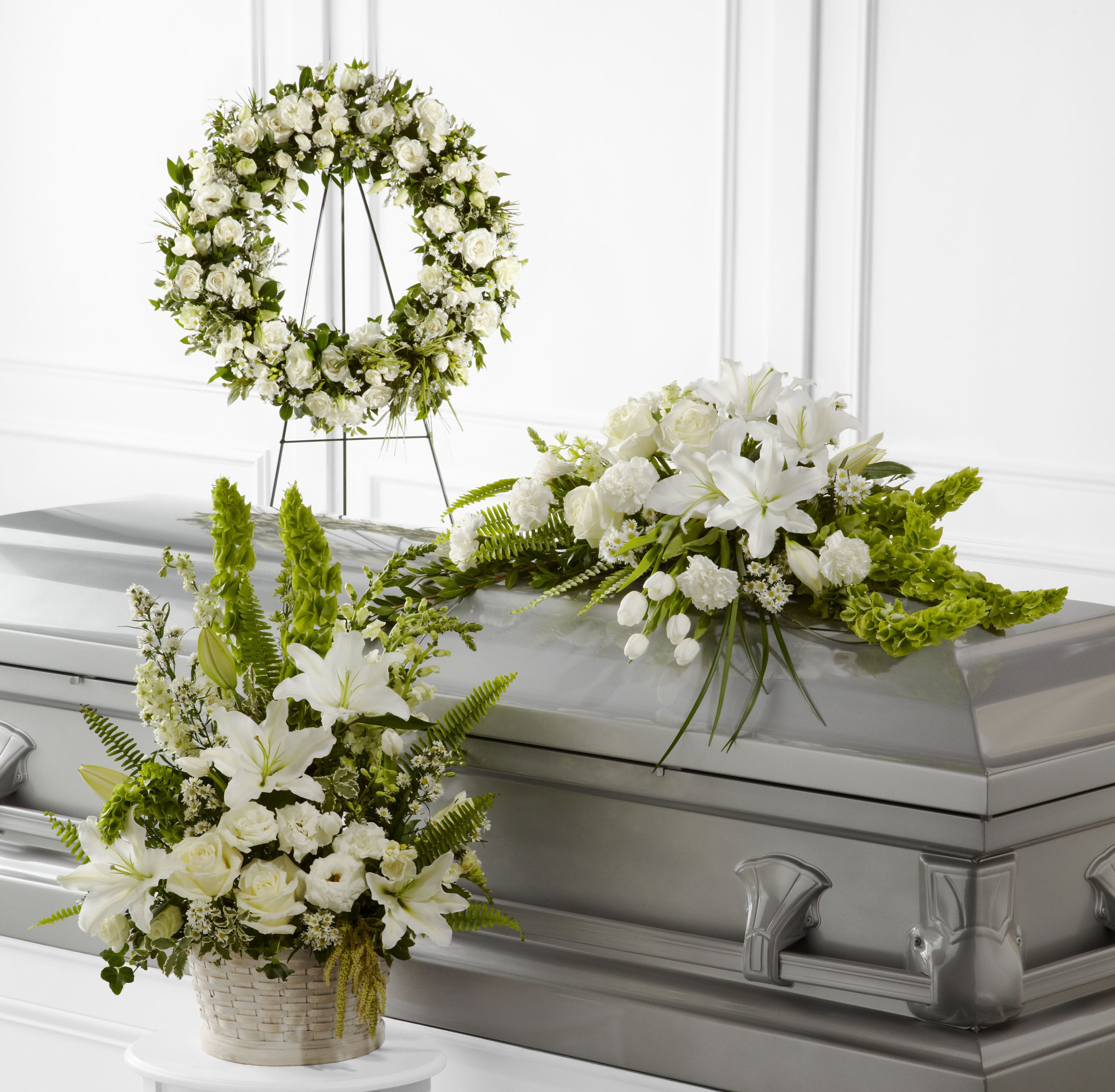White floral casket spray and wreath with lilies and roses
