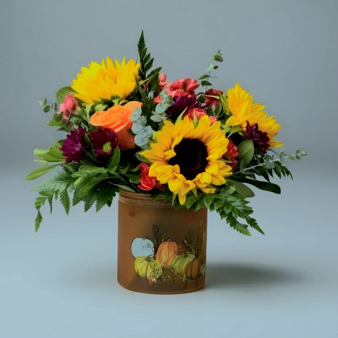 Sunflower and mixed flower arrangement in a brown glass vase