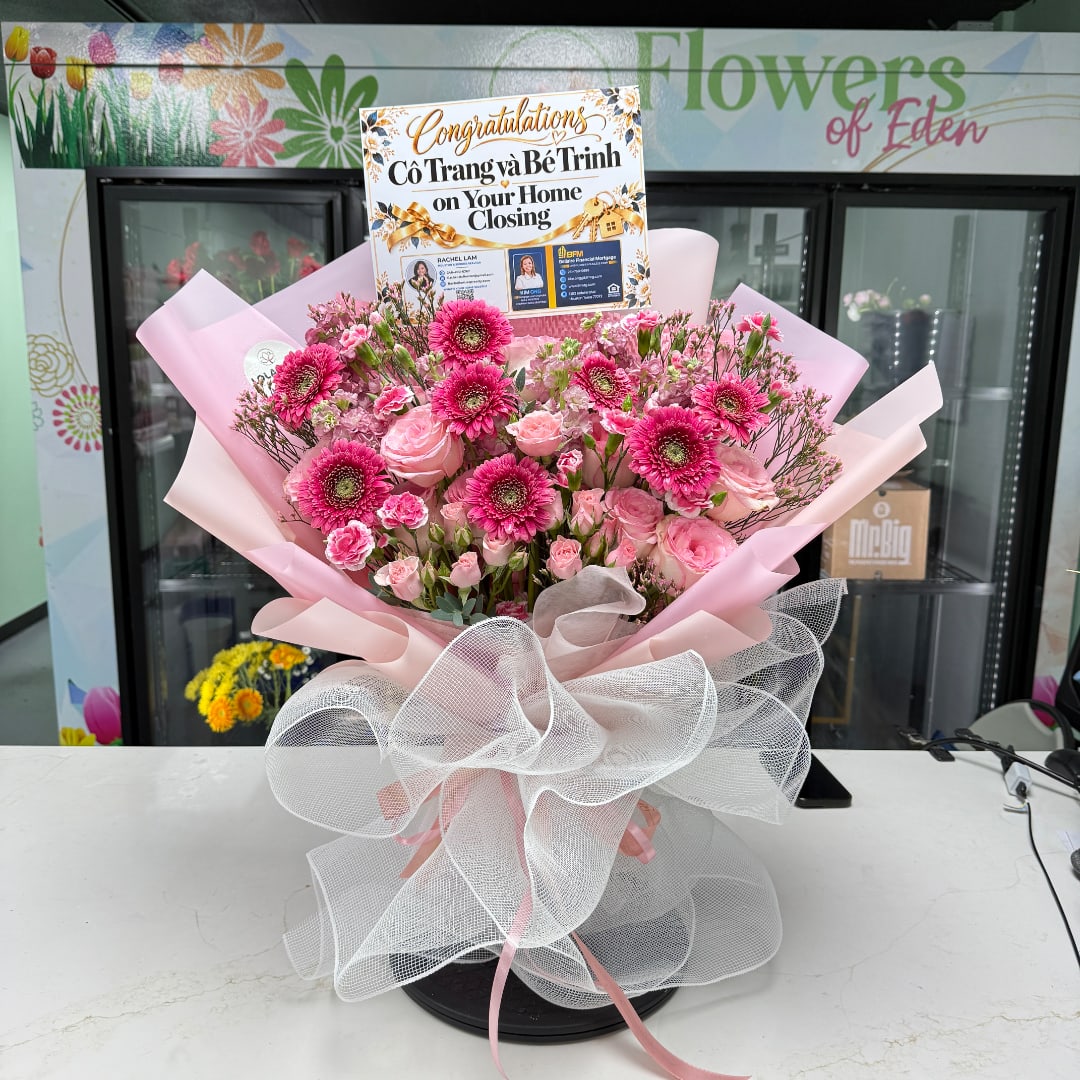 Pink flower bouquet with a congratulations sign in a shop setting