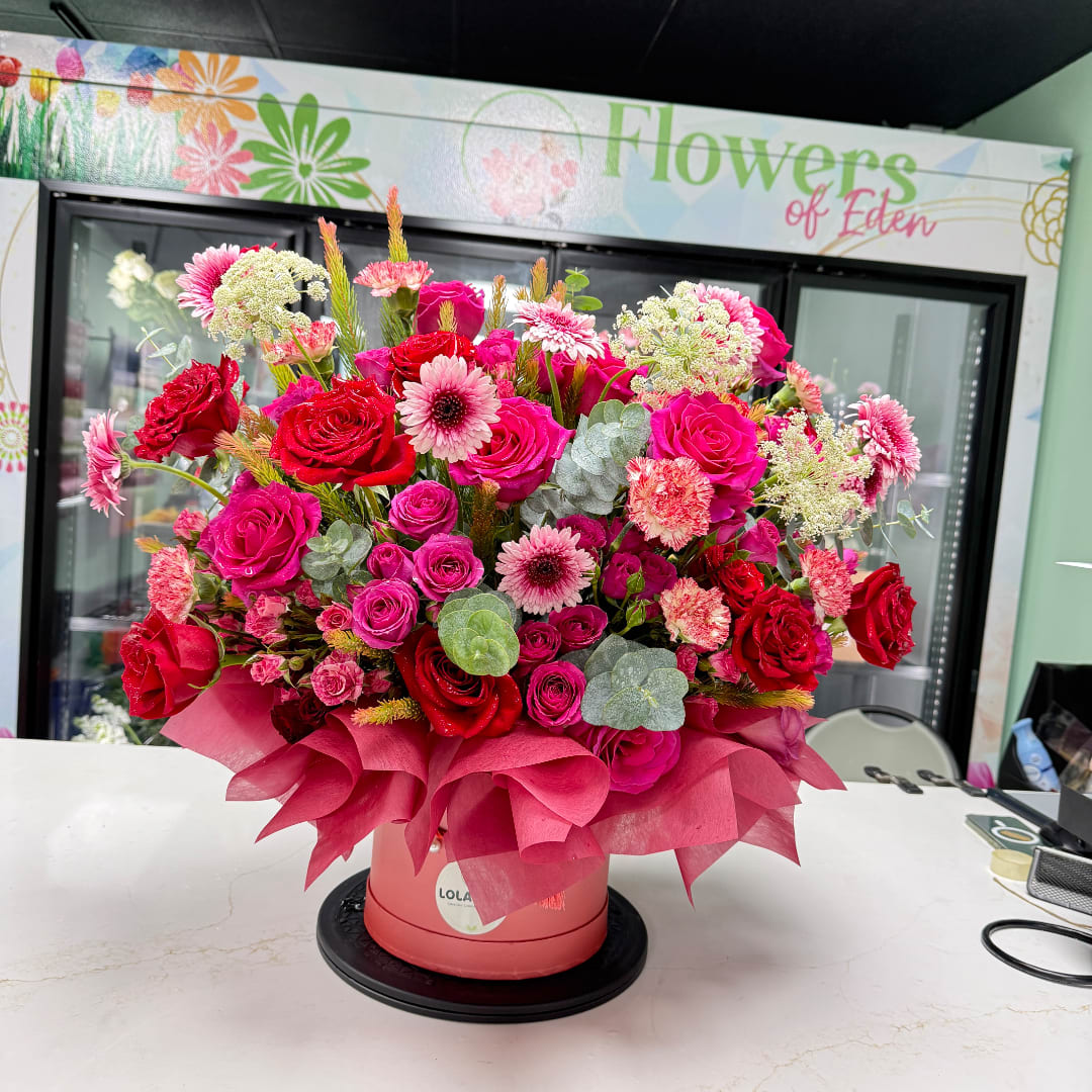 Large bouquet of pink and red roses in a round pink box