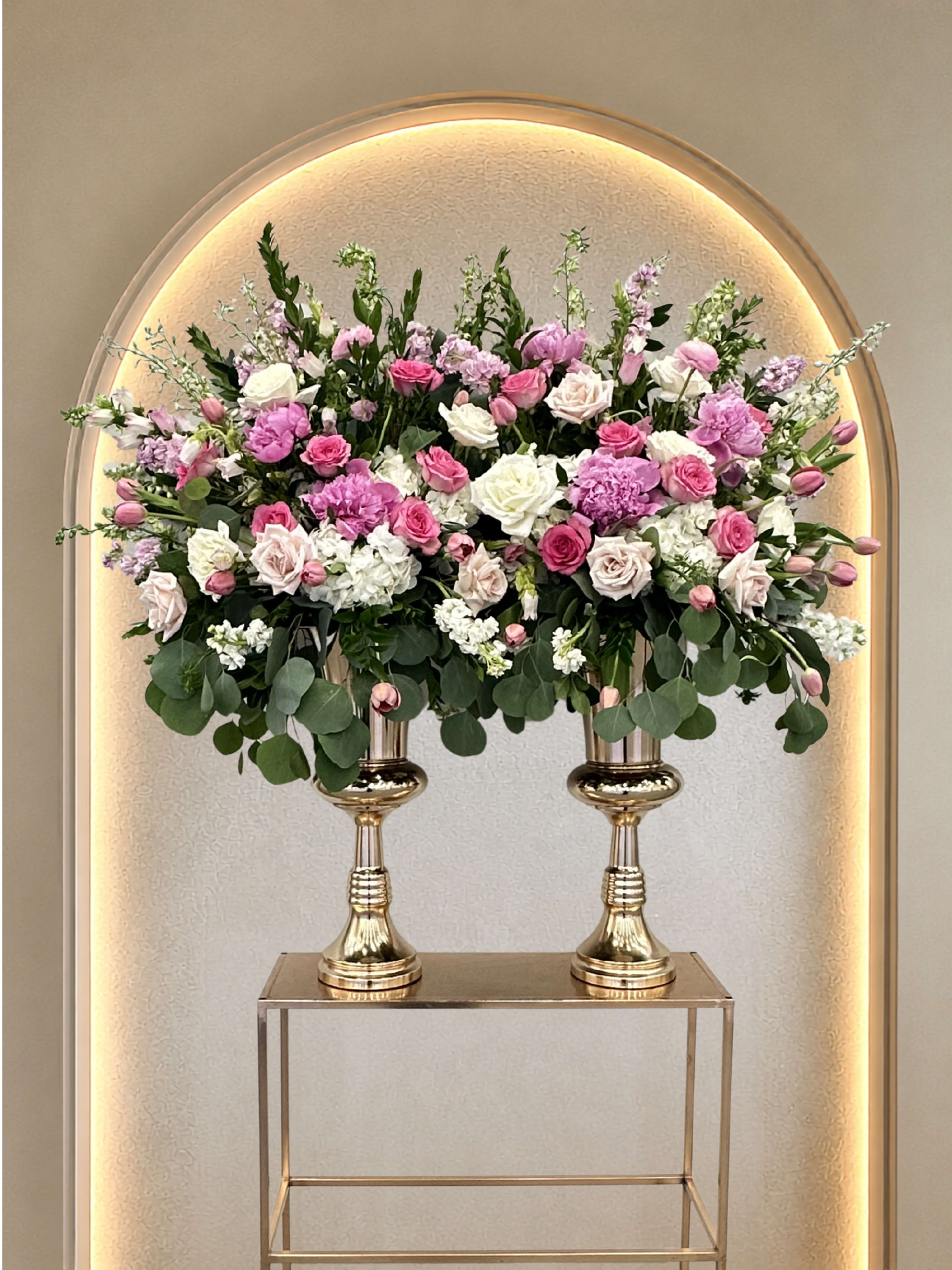 Vort Arrangement Dual - Soft blooms rising from a beautiful set of gold pedestal vases in this dual Vort arrangement. Custom requests are always available. 