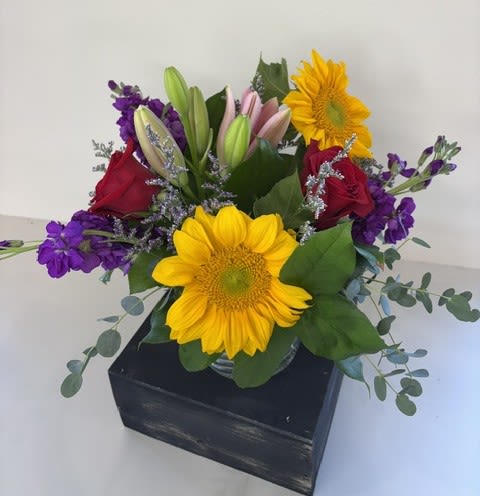Best Day Wishes - Best Day Wishes is a joyful arrangement designed to make any occasion feel extra special. Featuring radiant sunflowers, classic red roses, elegant pink lilies, and rich purple stock, this vibrant bouquet is bursting with color, warmth, and heartfelt charm. Whether you're celebrating a birthday, sending congratulations, expressing gratitude, or simply making someone's day a little brighter, Best Day Wishes is a beautiful way to share happiness. Handcrafted with the freshest blooms and arranged in a vase, it's a gift that's sure to leave a lasting impression.