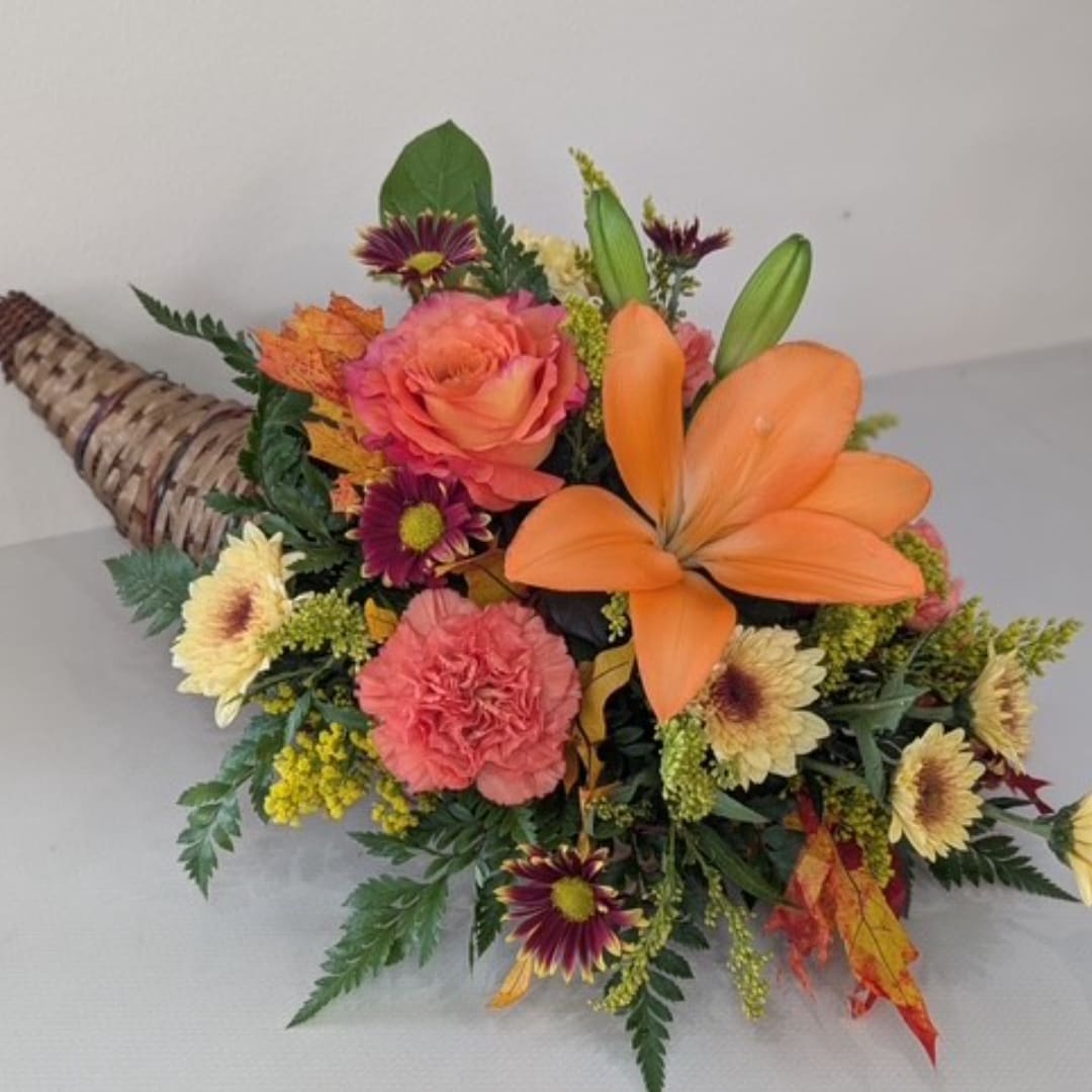 Orange and pink floral bouquet with lilies, roses, and daisies