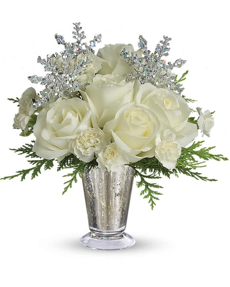 White roses and small white blooms with silver snowflake picks in a silver glass vase