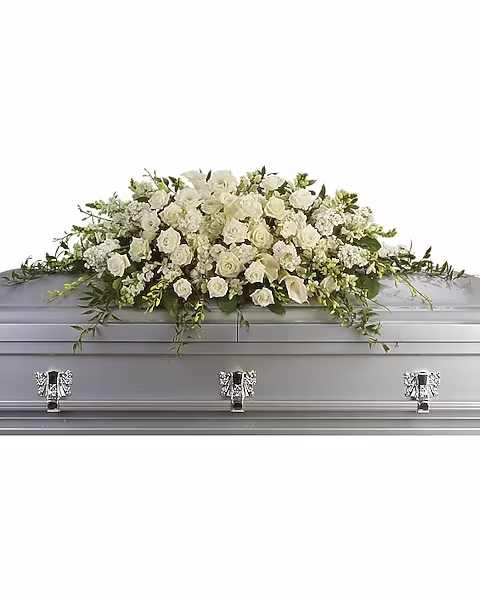 Purity and Peace Casket Spray - A stunning yet respectful testament in white, this spray for the casket includes roses, orchids, calla lilies and hydrangea accented by soft, trailing greens. White roses, orchids, large calla lilies and perfect stems of hydrangea. Approximately 47" W x 17" H.
