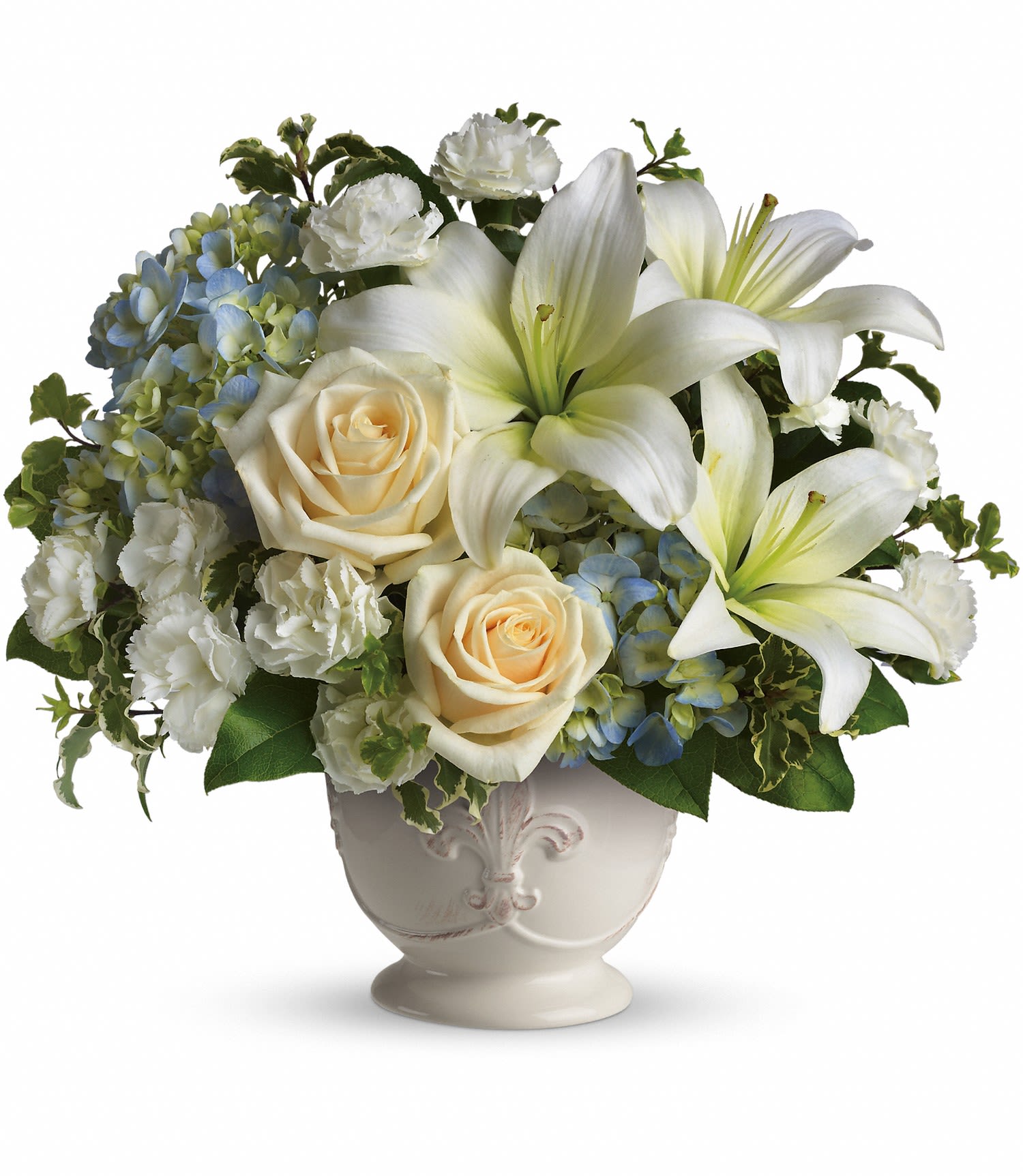 Beautiful Dreams by Teleflora - Soothing and respectful. Calm and compassionate. This beautiful collection of white and light colored blossoms will deliver your loving thoughts perfectly. Tasteful flowers such as light blue hydrangea, crème roses, white asiatic lilies, miniature carnations and more are delivered in a lovely white French Country Pot.